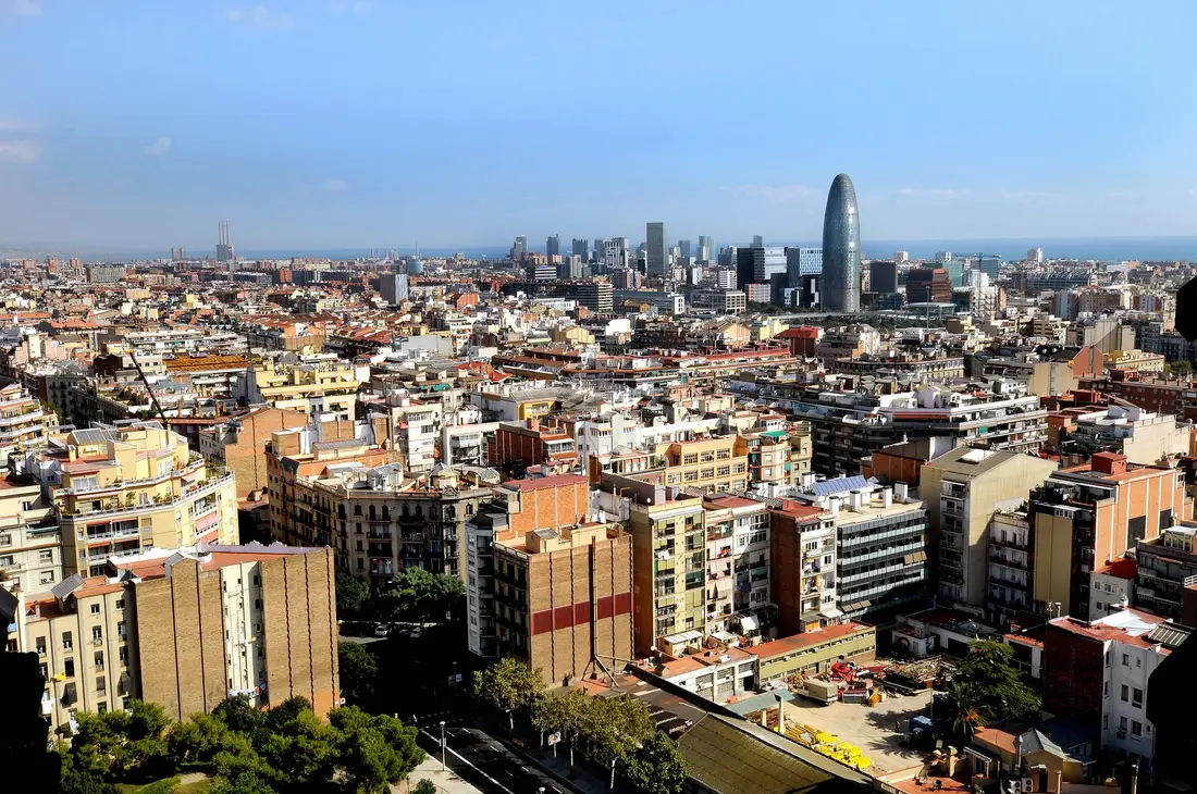 Vista de Barcelona hacia el mar en un día soleado, con la torre Glòries entre los edificios