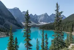 Turquoise Moraine Lake between fir trees and mountains in Banff National Park, Alberta