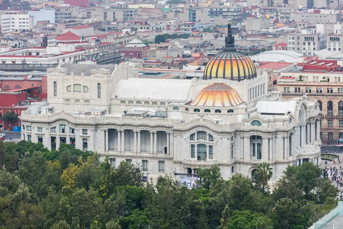 El Palacio de Bellas Artes de Ciudad de México visto desde lo alto, entre los árboles de la Alameda y los edificios del centro
