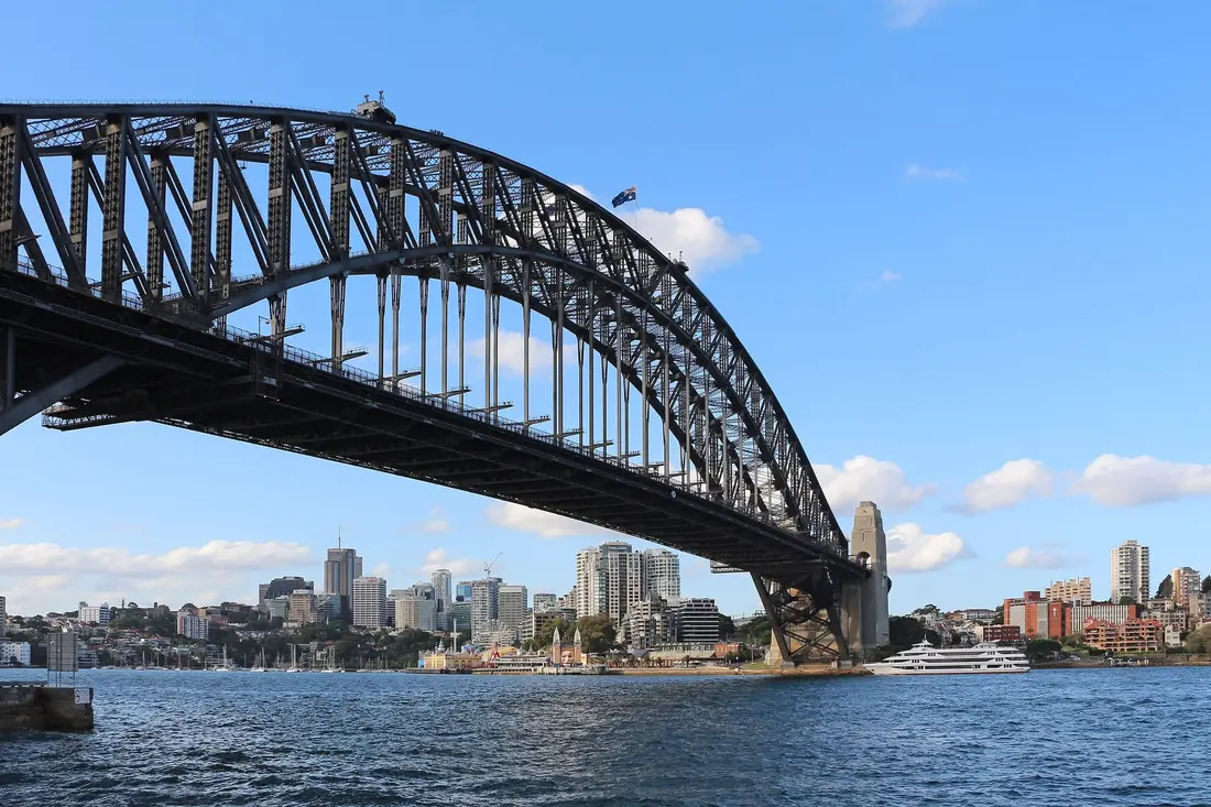 El Harbour Bridge de Sídney sobre la bahía, con los edificios de North Sydney al fondo y cielo azul